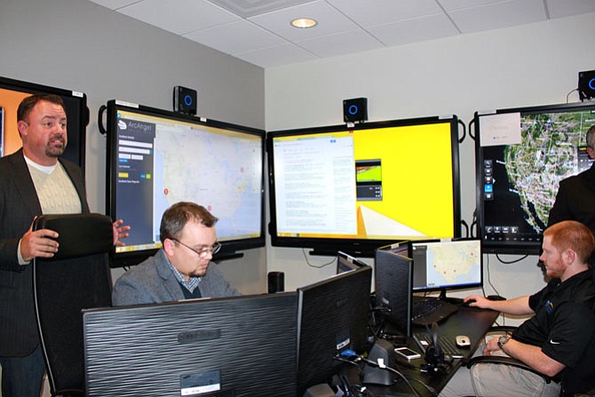 ArcAngel CEO John South talks about the app, ArcAngel, in the demo room while Operations Specialists Matt Oliver and Will Schworer check on potential emergency situations.
