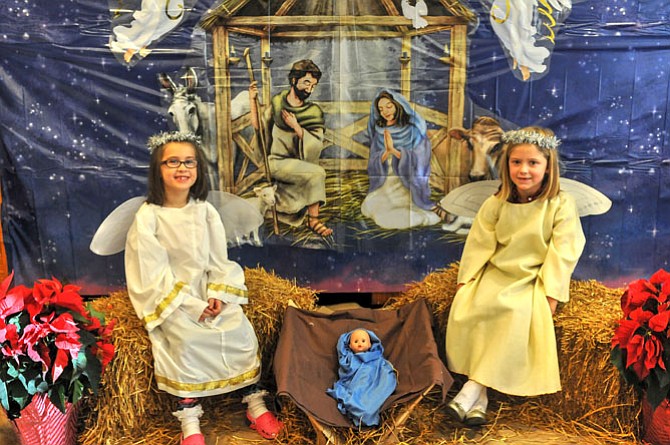 Slye Miller and Georgia Grace Ruhlen pose as angels in the Christmas Crèche at St. Mary’s School Bazaar on Saturday afternoon. Proceeds from the photo donations benefitted Mary’s Shelter in Fredericksburg.
