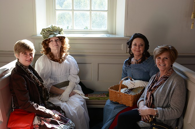(From left) Karlie Herbst of Alexandria, Laurie Kittle of Alexandria as “Mrs. Sinah McCarty of Mount Airy,” Janis Harless of Mason Neck as “Ann ‘Nancy’ Mason of Gunston Hall,” and Molly Herbst of Alexandria talk about seasonal church decorations in the historic Pohick Church during the church’s Christmas Mart. 