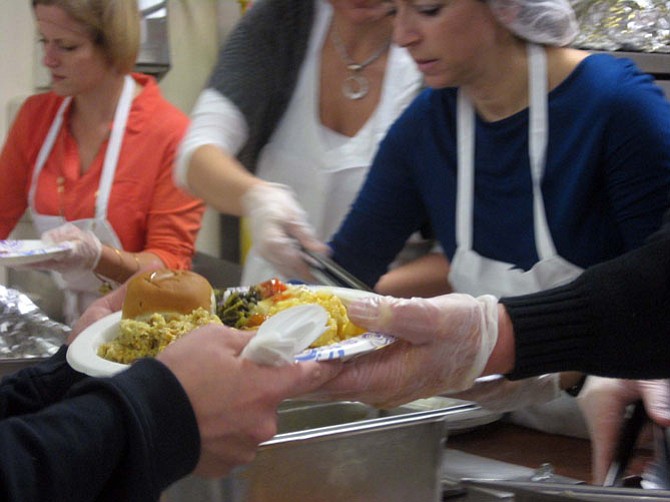 Invited families and guests staying at shelters run by Shelter House receive a Thanksgiving lunch served by Gov. Terry McAuliffe on Thursday, Nov. 27, in Fairfax.
