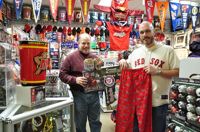 Peter Averinos, owner, and Brian Aguiar, manager, of Hall of Fame Card and
Collectibles point out a few of their most popular sports items.