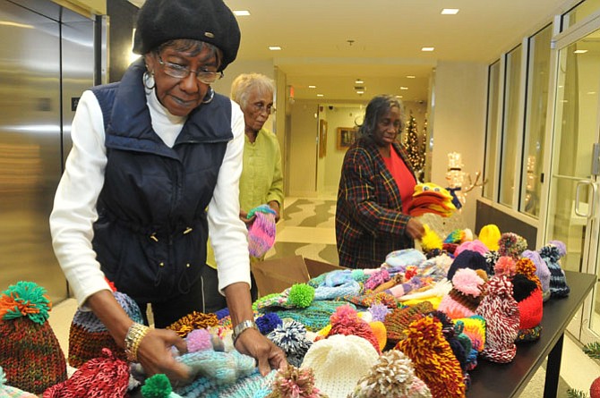 Margaret Caple, Pearl Turner and Barbara Norton arrange the caps on a table to display to the ABR crafters.