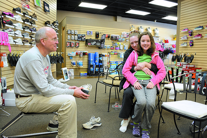 Metro Run & Walk co-owner Mark Russell (left) fits Ashley Baldeon and her daughter Bianca of Springfield (fourth grade at Saratoga Elementary School) for a new pair of running shoes.
