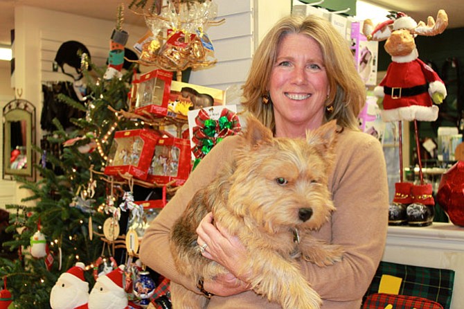 Sales associate Gail Rezenders - with The Saddlery’s mascot RJ - in front of the holiday items in the shop.
