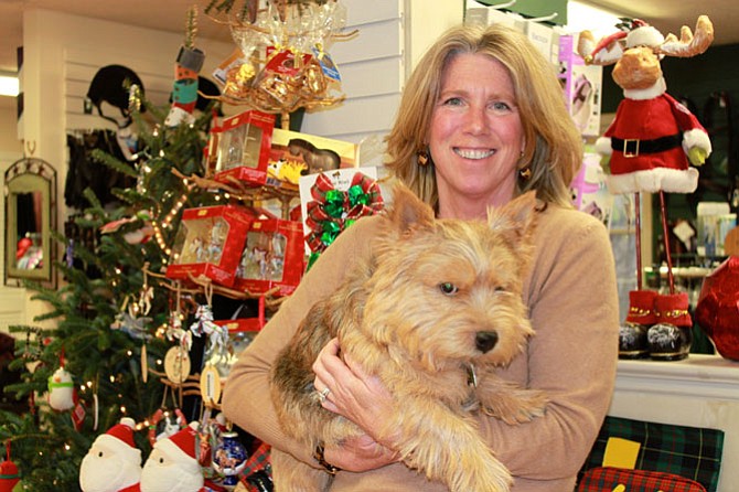 Sales associate Gail Rezenders - with The Saddlery’s mascot RJ - in front of the holiday items in the shop.
