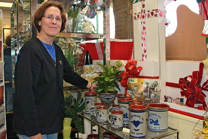 Herndon Florist sales associate Bobbe Duquette showcases the Herndon pottery featured in the shop, ready to buy or to be filled with flowers.