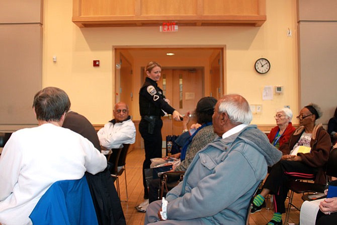 Herndon officer Denise Randles holds out the microphone to a concerned citizen at the Senior Safety Summit on Dec. 5.
