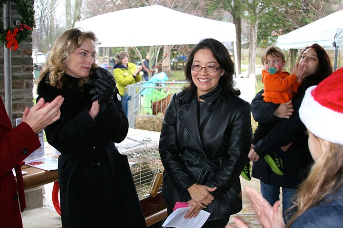 President of the Friends of Clemyjontri Park Kathleen Helein joins the audience in applauding Grace Wolf after the announcement that she will be taking over for Rip Sullivan as the new Dranesville District Representative on the Fairfax County Park Authority Board.
