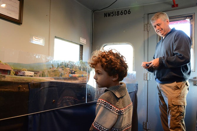 Adriano Oddi of Burke (Kindergarten at Nativity Catholic School) checks out the N Gauge electric train setup at the Fairfax Railroad Museum. Kent Smiley of Alexandria (right) with the Northern Virginia NTRAK model train club ran the station.
