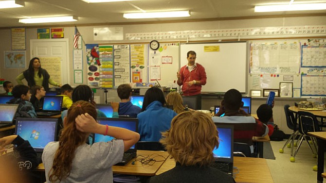 Keene Mill Elementary School Technology Specialist Brian Lachance instructs sixth grade students on how to get started during the “Hour of Code.”
