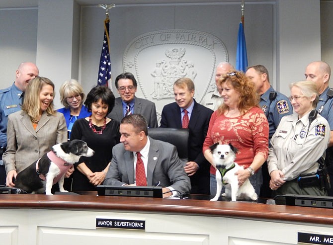 What do you think about that? Both dogs and animal advocates watch Mayor Scott Silverthorne sign the tethering ordinance into law, Monday, Dec. 15.
 