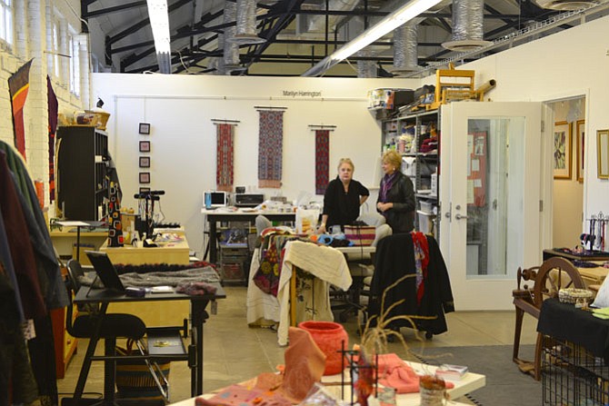 Pat Moran of Fairfax Station talks with an artist in the Fiber Room where eleven fiber artists work.
