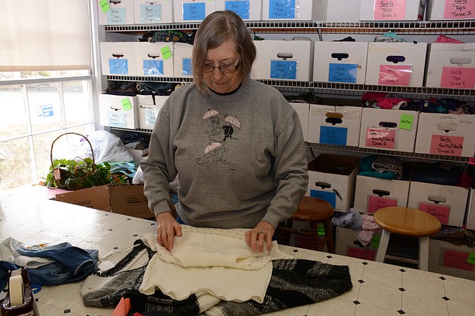 Alexandria resident Pat Bauer inspects and folds donated clothing at Koinonia in Springfield. 