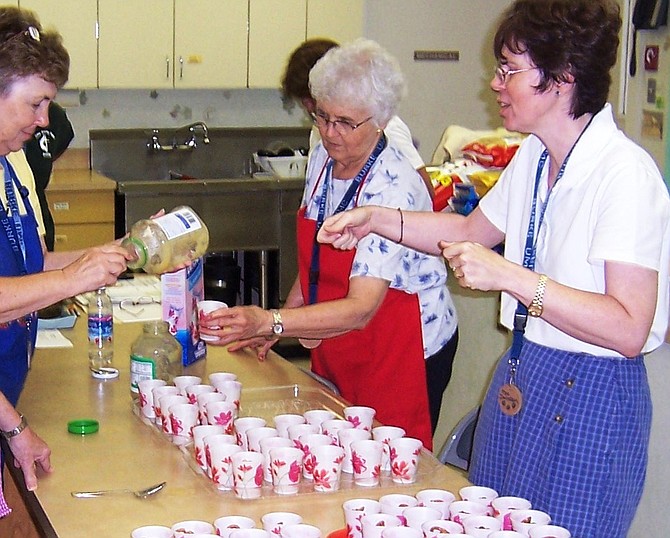 (From left) Shirley Walker, Kathy Davidson and Margaret Yowell measure out applesauce to serve to hypothermia prevention shelter guests at Burke United Methodist Church.
