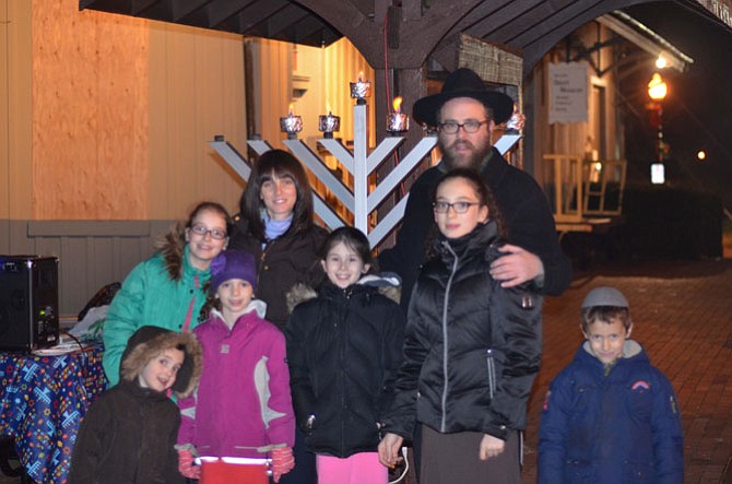 Rabbi Leibel Fajnland with members of his family near the giant menorah after the community Chanukah celebration in downtown Herndon. Rabbi Leibel and Nechamie Fajnland are directors of the Chabad Reston-Herndon.