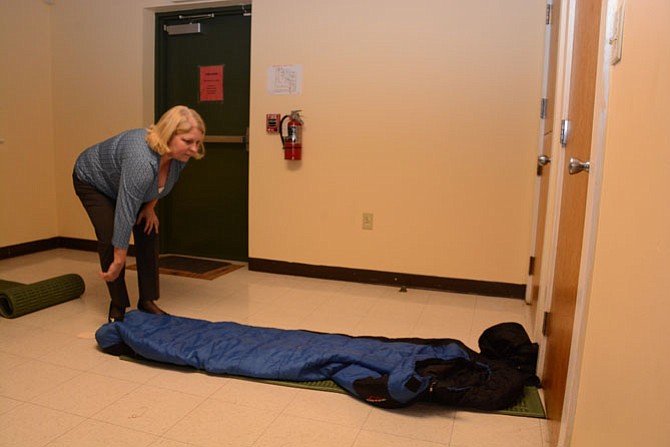 Sherry Edelkamp of Alexandria rolls out sleeping bags at Rising Hope Mission Church, a shelter site for New Hope Housing.