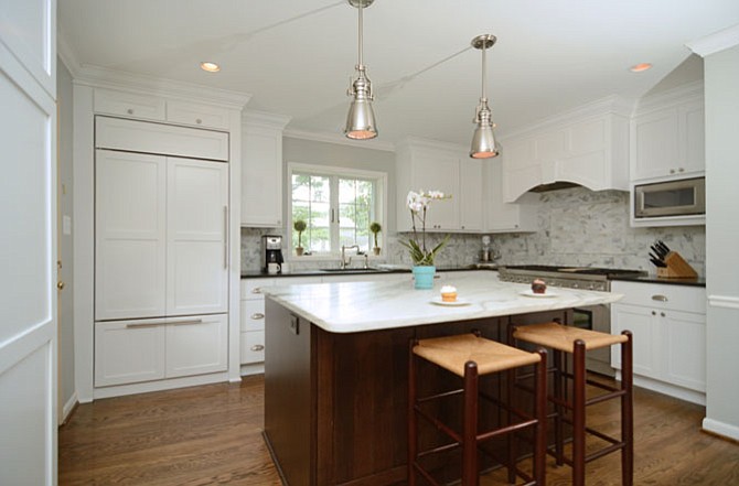 The newly remodeled kitchen of this Arlington home has cabinet-front appliances, marble and granite countertops, and an island for family seating. 
