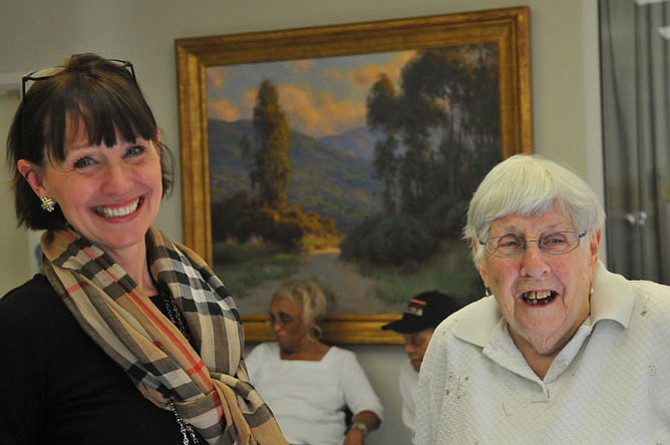 Annie B. Rose House Senior Support Specialist Michele LeFrancois talks with resident Frances Vidal after all the 250 emergency go-kit backpacks are filled. 