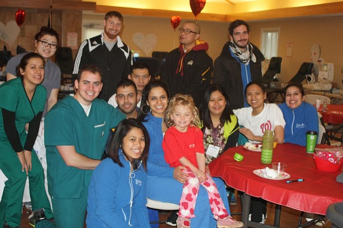 Sadie Lauer sits with members of the Inova Blood Donor Services team at the 2014 Friends of Sadie blood drive.