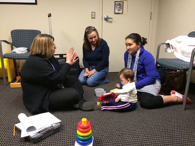CSB’s Infant and Toddler Connection interventionists Olga Jiminez and Belkis Negron explain development to mother Cecie and daughter Allison.