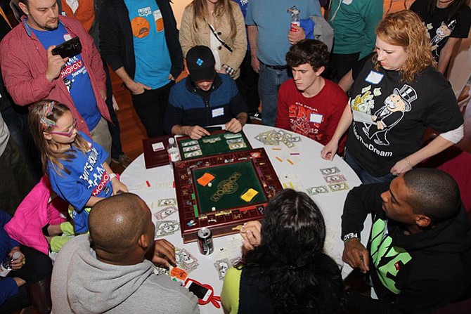 Gamers crowd around the board at a previous Lorton Community Action Center Monopoly tournament.
