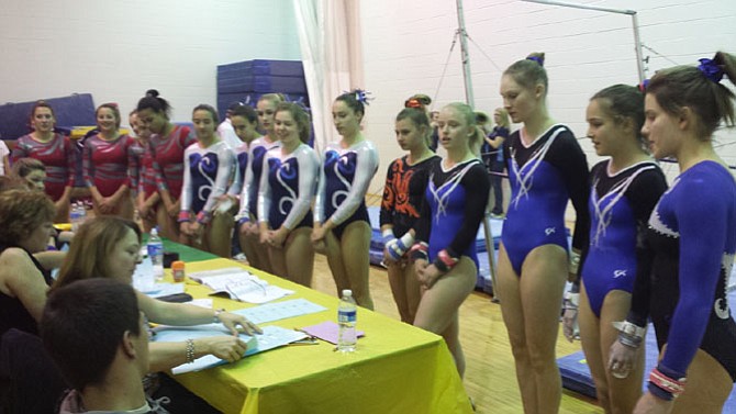 Conference 6 gymnasts check in before their bar routines during the 6A North region championship meet on Feb. 11 at Lake Braddock Secondary School.