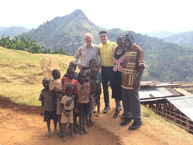 A group of Arlington Academy of Hope teachers and volunteers including, from left, Dean Scribner, Justin Scribner, Arlington Academy of Hope head teacher Sarah Sabano and organization founder John Wanda, along with a group of children from the village, en route to a Sunday morning church service. Mount Nusu, the mountain in the background, is a popular hiking destination in Uganda.