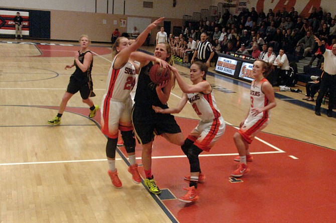 Langley junior Paige Galiani tries to split a pair of West Springfield defenders during the 6A North region quarterfinals on Feb. 28.