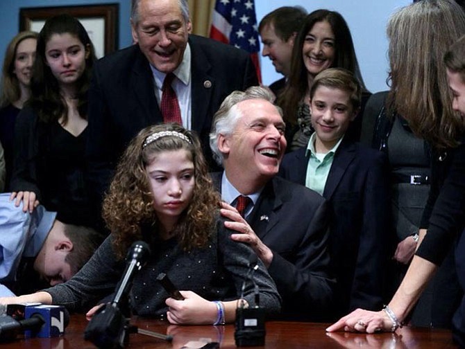 Haley Smith jumped into Gov. Terry McAuliffe’s (D) lap as he signed legislation legalizing the use of marijuana extract for medicine to treat epileptic seizures.