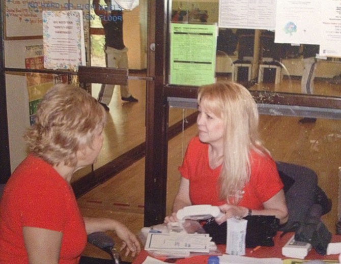 Personal trainer Patty Jarrett (right) prepares to check a club member’s blood pressure and body fat index at the Burke Racquet & Swim Club 25th Anniversary open house and fitness fair.
