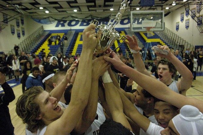 Members of the Westfield boys’ basketball team celebrate winning the 6A North region championship on March 7 at Robinson Secondary School.