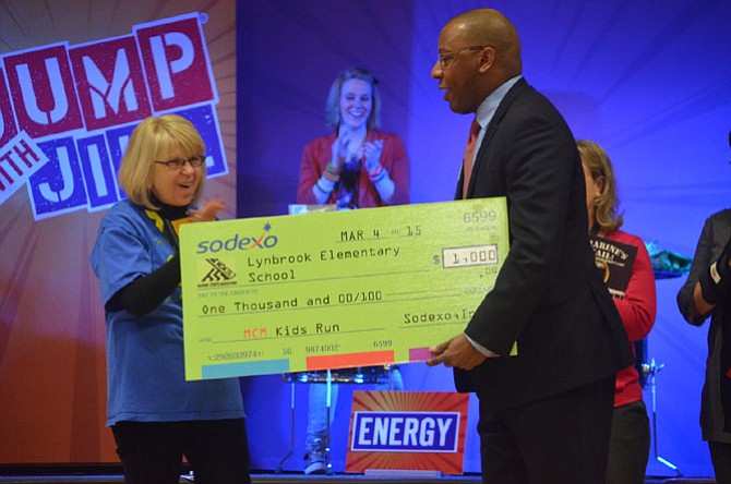 Lynbrook Principal Mary McNamee receives a check for $1,000 from Eugene McKnight, area general manager of Sodexo. Sodexo in partnership with the Marine Corp Marathon granted money to the school’s P.E. department.