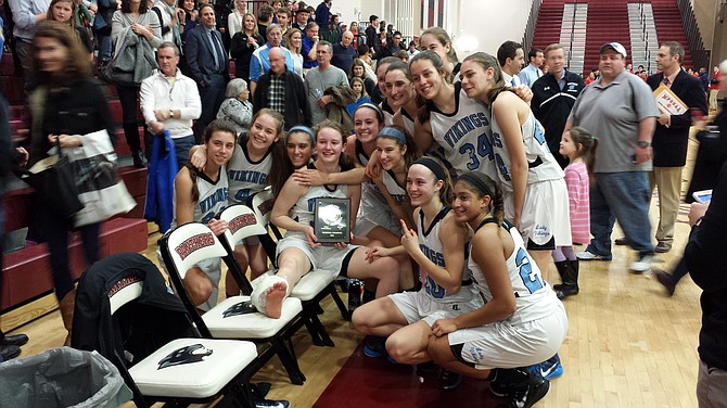 Members of the Whitman girls’ basketball team celebrate winning the 4A West region championship with injured teammate Marie Hatch on Monday night at Paint Branch High School.
