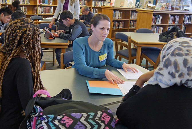 Karysa Murray, a first-time tutor volunteer helps Ferina Mohammed and Yulia Ekubezghi with English in the Building Better Futures program at T.C. Williams.
