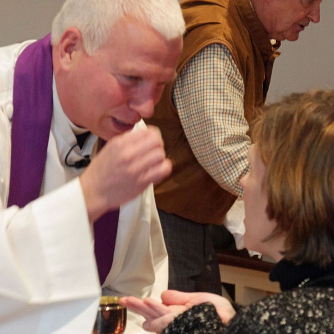 The Rev. Chuck McCoart offers the sacrament of water and wine symbolizing the body and blood of Christ at Communion during the service at Emmanuel Episcopal Church on the second Sunday of Lent. 