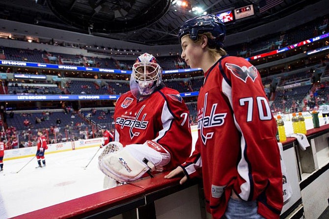 Washington Capitals goaltender Braden Holtby greets 13-year-old Healy, Alaska, native Caleb Graham as Graham watches warmups from the Capitals’ bench prior to the team’s March 13 game against the Dallas Stars at Verizon Center in Washington, D.C. Graham suffers from a life-threatening heart condition and had his wish to meet Holtby granted by Make-A-Wish.