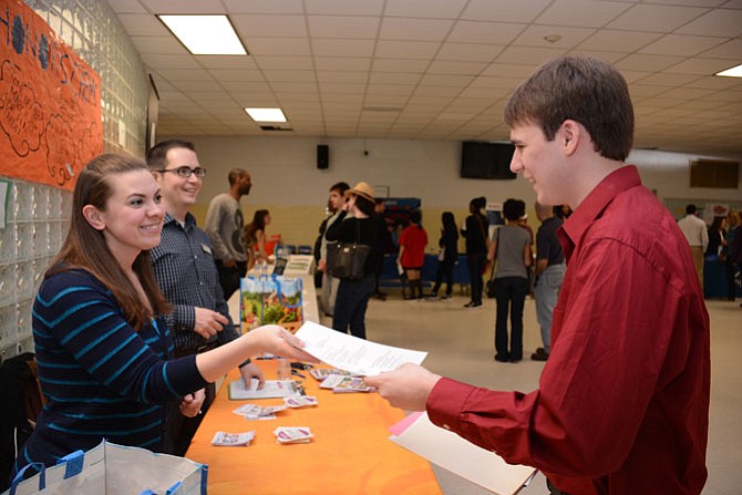 Wegmans recruiter Janet Walker (left) receives a resume from hopeful applicant Jackson Muse of Fairfax (right).
