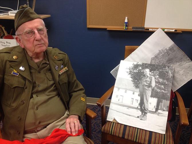 Richard Graff, formerly of Vienna, showed Nysmith students from Herndon a photo taken of himself on V-E Day in 1945 when war in Europe came to an end 70 years ago. He still wears his uniform when sharing experiences of the war, and brings a Nazi flag he captured.