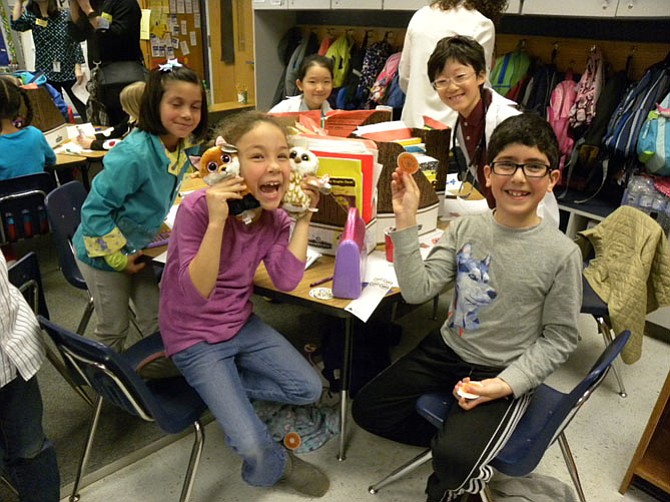 Alexandra Lujan’s second grade class at Westbriar Elementary School in Vienna learn about the businesses in the community during Junior Achievement of Greater Washington’s “JA in a Day” program. From left, Ariana, Sophia, Abdullah and Jay create a new doughnut flavor to attract customers to their shop.
