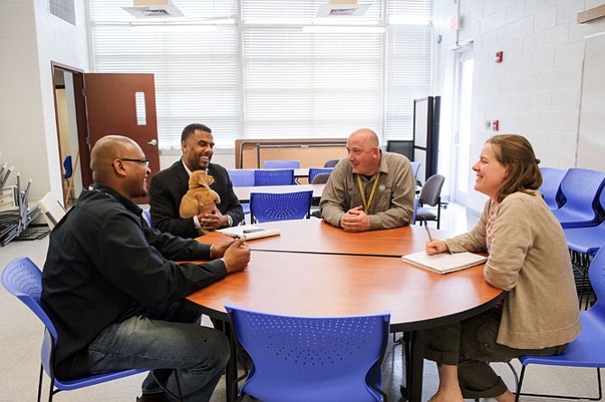 Alexandria Deputy Director of Administration Alfred Coleman holds a puppy as he talks with city team members Pelham Park (left) and Kevin Jones and AWLA Director of Animal Care Abbie Hubbard.