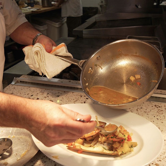 Poteaux adds “some” of the juice until the shrimp and clam bouillabaisse looks just right.