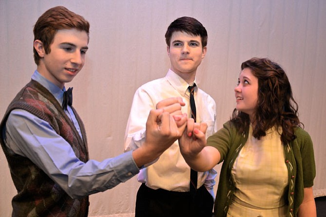 From left, Junior Scott Burrows, senior Darion Roberts and senior Mallory Astrow make a pact their future selves will eventually break in West Springfield’s production of Stephen Sondheim’s lyrically complex musical “Merrily We Roll Along.”