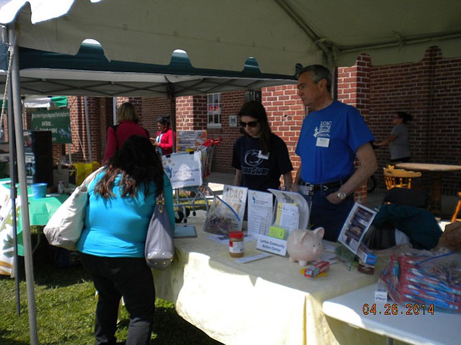 Lorton Community Action Center volunteers Bill Evans and Rachel Grippo talk to community members at the 2014 Springfest.