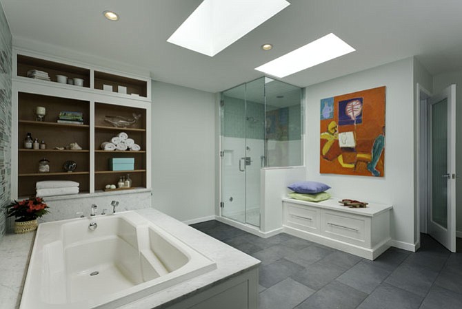 Modern art in bold colors pops against pale tile in this Potomac, Md., bathroom-turned-spa retreat. 