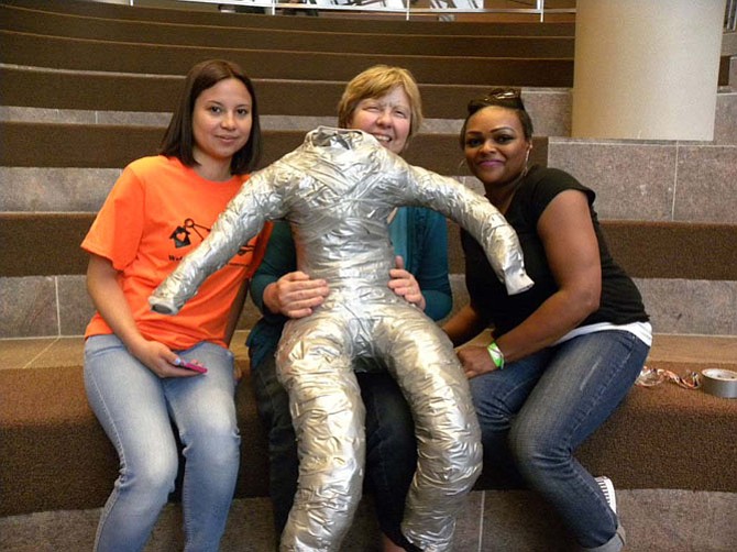 From left, Ana Sermeno of Manassas, Robin Renner of Arlington, Tracy Medley of Waldorf, Md., pose with their mannequin during a homeless mannequin assembly workshop in the Fairfax County Government Center on Friday, April 17.