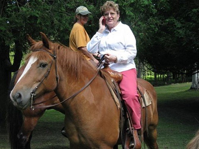 Karen Brown multitasks riding a horse and talking on a Blackberry.