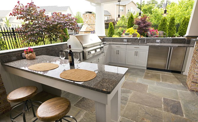 The outdoor kitchen to this poolside solution is equipped with both a traditional grill and a power burner. There's also dining for two; a refrigerator and many amenities.
