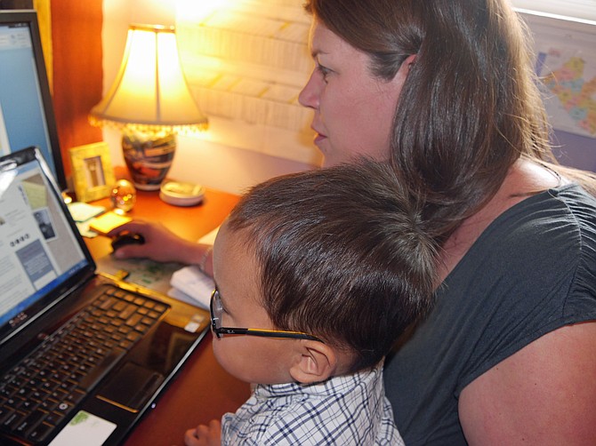 Jack bounces up and down on Jennifer’s knee as she attempts to write a grant application while occupying her newly adopted Chinese son, Jack.