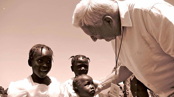 The late Father Richard Martin (right) spends time with Haitian children while visiting their country as part of his charitable project Operation Starfish.
