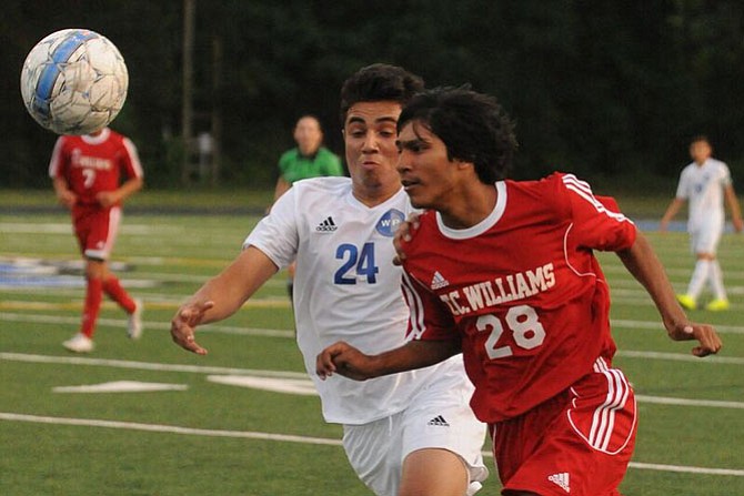 T.C. Williams forward Jason Sookia and West Potomac defender Kevin Aviles compete for the ball during Tuesday’s match at West Potomac High School.
